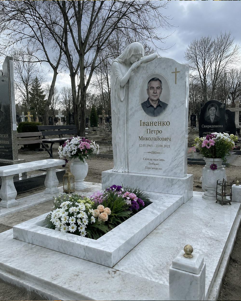 Меморіальний комплекс зі світлого каменю зі скульптурою скорботної та лавкою