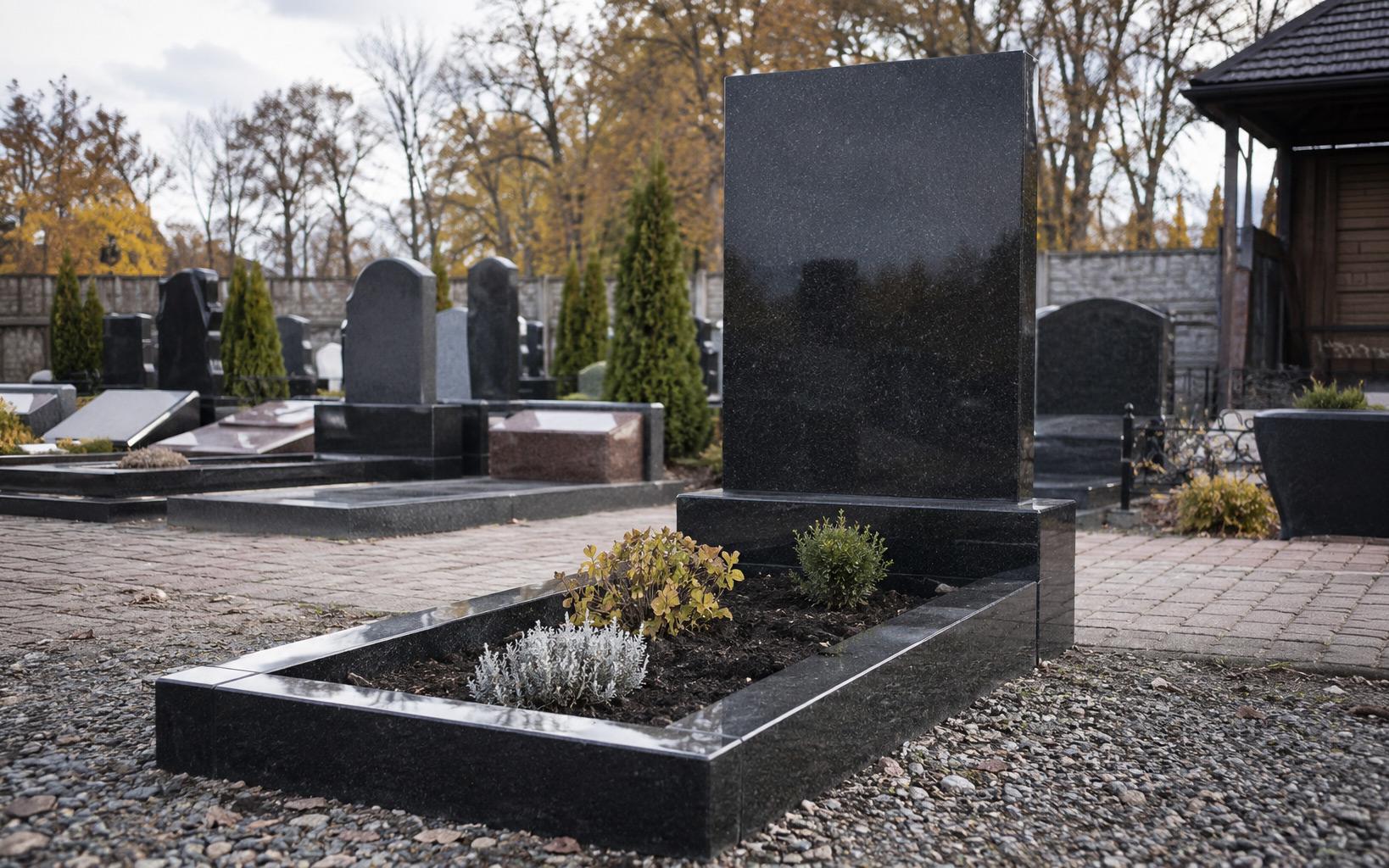 Одинарний гранітний пам'ятник з чорного габро з квітником — на кладовищі при заході сонця